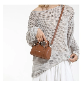 Close-up of caramel brown mini Boston bag with litchi grain texture and white logo