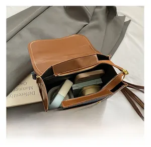 Detail view of the brown leather crossbody bag showing internal storage for essentials