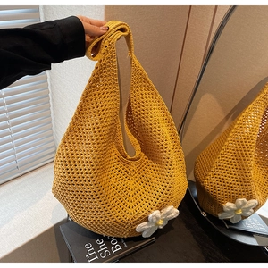 Dettaglio borsa tote in maglia gialla con margherite 3D e motivo a trama traforata