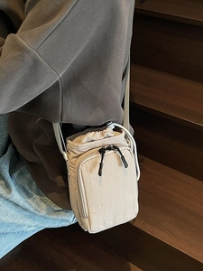 Minimalist beige nylon crossbody bag with drawstring closure and adjustable strap for women