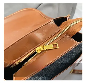 Detail of vintage denim and brown leather patchwork with golden metal zipper hardware
