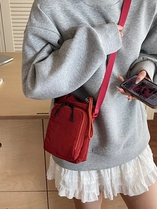 Red nylon crossbody water bottle bag with drawstring closure and adjustable strap