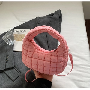 Sac à main matelassé rose avec bandoulière amovible et poignée dans un décor lifestyle