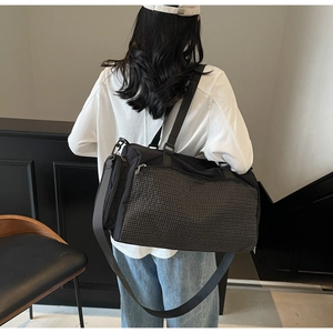 Detail der schwarzen Sporttasche mit Karomuster-Tasche von einem Model getragen