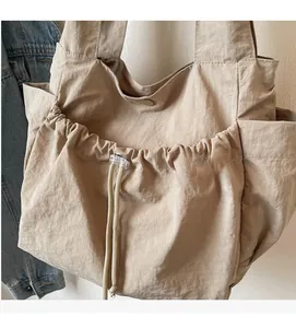 Detail der khakifarbenen Nylon-Tote Bag mit Kordelzugtasche und Knitterstruktur