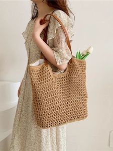 Brown woven tote bag with leather straps and tulip detail in a minimalist home setting
