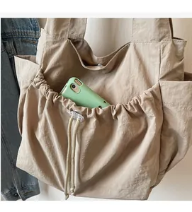Detail der strapazierfähigen Kordelzug-Seitentasche einer beigen Nylon-Tragetasche