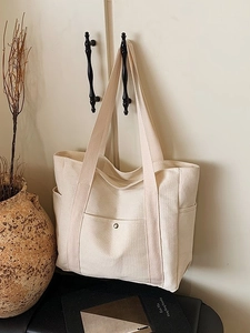 Minimalistische große cremeweiße Canvas-Tragetasche mit Vordertasche im Wohnambiente