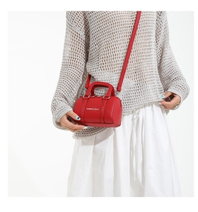 Red mini Boston bag with Fashion & Bags text shown on model with shoulder strap