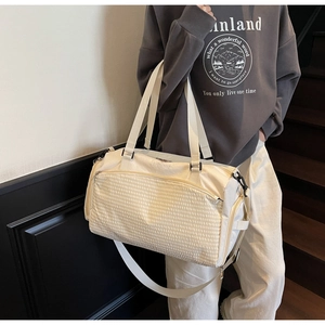 Detailansicht der cremefarbenen Sporttasche mit Waffelstruktur-Tasche und Gurt