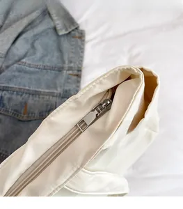 Détail de la fermeture éclair en métal argenté sur un grand sac fourre-tout en nylon