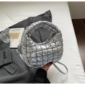 Détail du sac hobo matelassé argenté stylisé sur un blazer avec des accessoires