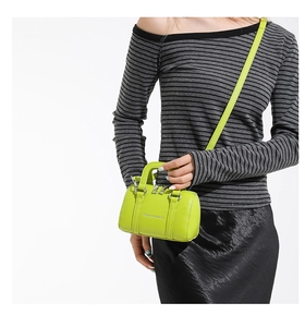 Model showing a neon green Boston bag with lychee texture and silver logo detail