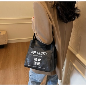 Detail of waterproof DuPont paper tote featuring Stop Anxiety slogan and bold typography