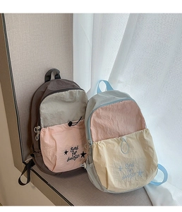 Detailed view of color-block nylon backpack with crinkle texture and star embroidery