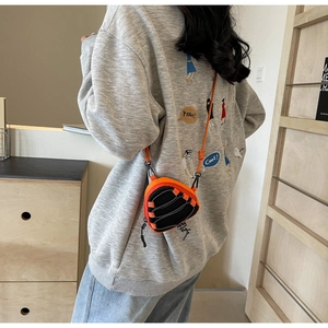 Detail of trendy orange and black techwear mini crossbody bag with rope strap