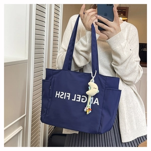 Détail du sac cabas en nylon bleu marine avec inscription et pendentif lune jaune