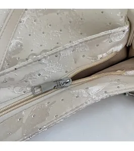 Vue macro du curseur en métal argenté et tissu jacquard haut de gamme avec perles