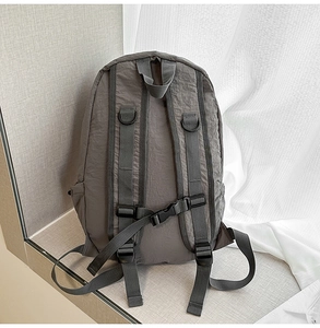 Detail of dark grey backpack back panel with padded straps and adjustable chest buckle