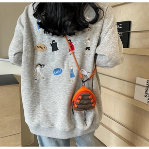 Outdoor style orange triangular mini crossbody bag shown on model with woven lanyard