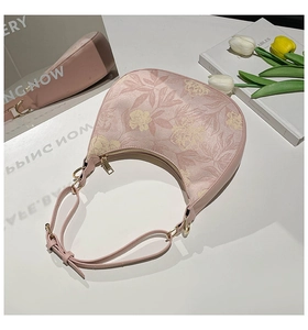 Detail of pink hobo bag with beige peony floral texture and adjustable strap