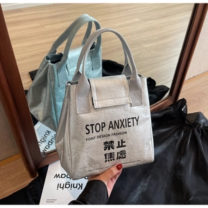 Close-up of metallic silver DuPont paper tote bag with Stop Anxiety printed text