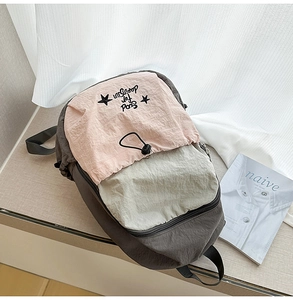Detailed embroidery and drawstring pocket on contrast color nylon school backpack