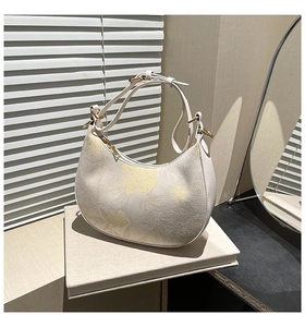Detail of floral jacquard hobo bag with smooth beige leather trim and gold metal zipper