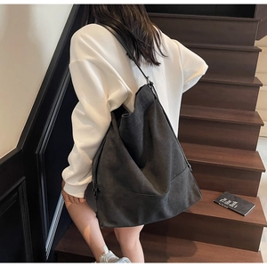 Modell mit großer schwarzer Canvas-Tragetasche über weißem Hoodie mit schmalen Riemen