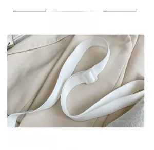 Detail of adjustable white nylon shoulder strap with durable plastic buckle for crossbody bags
