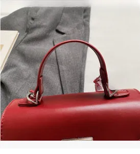 Close-up of red vintage handbag with textured leather and sturdy silver metal buckles