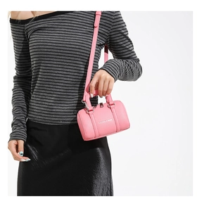Detail of pink mini Boston bag with lychee texture and adjustable crossbody strap