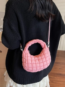 Sac bandoulière rose matelassé en forme de croissant avec texture douce et moderne
