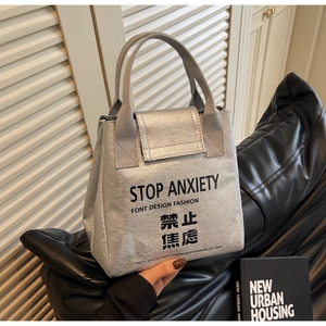 Close-up of silver Tyvek insulated bag with Stop Anxiety print and wrinkled texture