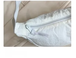 Close-up of white nylon dumpling bag showing smooth zipper detail and ripstop texture