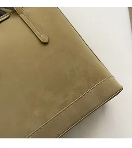 Close-up of khaki tote bag showing matte texture and precise double-stitching detail
