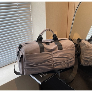 Detail of grey-purple waterproof nylon travel bag with pleated stitching and adjustable strap