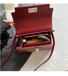 Interior view of wine red floral embossed handbag showing multiple spacious compartments