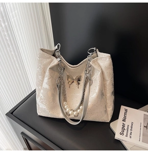 Détail du sac cabas blanc avec papillon argenté et bandoulière en perles