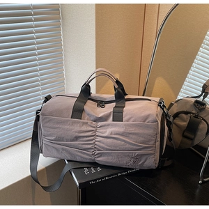 Detail view of purple nylon travel bag with vertical pleats and sturdy black handles