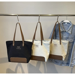 Detail of minimalist canvas tote bag with leather straps and SOBAG logo printing