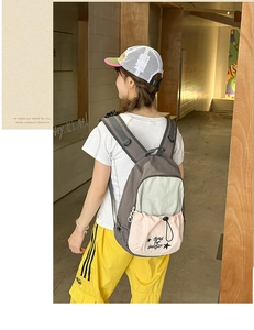 Detail view of stylish multi-color patchwork backpack with gray tones and pink drawstring cords