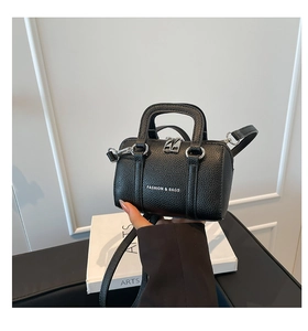 Détail d'un mini sac oreiller en cuir litchi noir avec fermeture éclair argentée