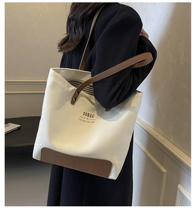 Detail of canvas tote bag with brown leather handles and SOBAG logo for daily commute