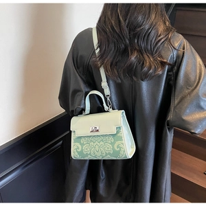 Detail of mint green floral handbag with metal twist lock and jacquard texture