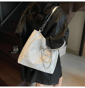 Détail du sac cabas blanc à texture scintillante avec chaîne argentée et perles
