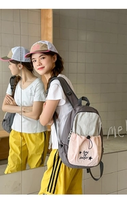 Detail of color-block backpack showing pink drawstring pocket and aesthetic star print