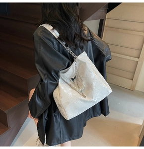 Détail du sac blanc à motif papillon avec chaîne argentée et perles sur mannequin