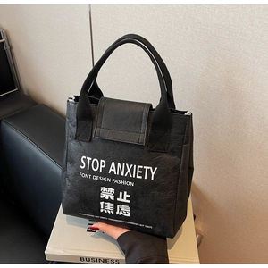 Detail of waterproof Tyvek tote with Stop Anxiety slogan and wide woven handles