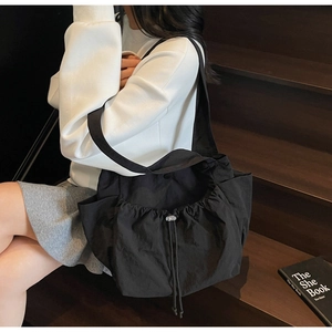 Close-up of black drawstring tote bag showing durable water-resistant nylon fabric texture